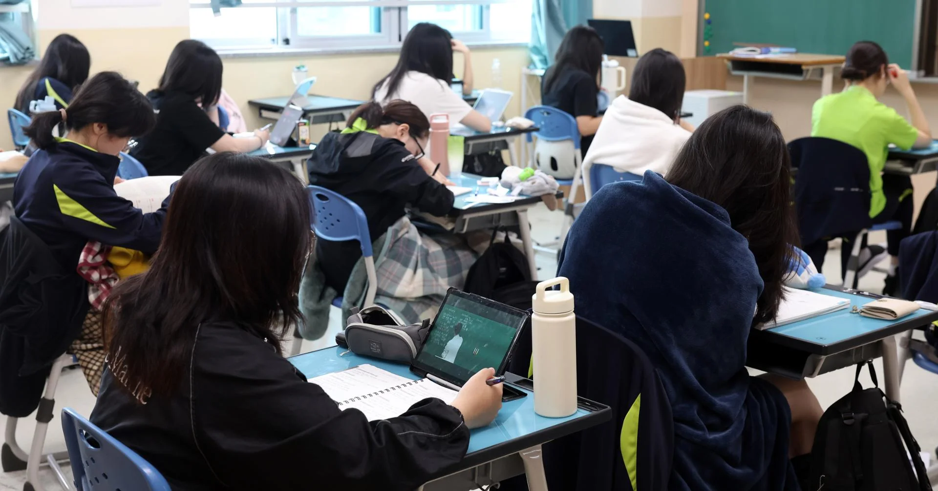 Ảnh bóng đá trên máy tính bảng trong lớp học với các học sinh đang tập trung học tập