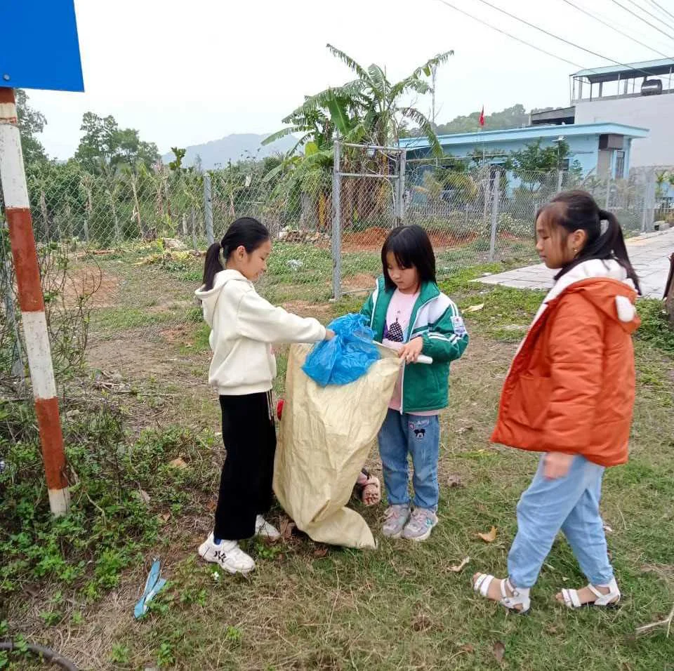 Hình ảnh bảo vệ môi trường với ba bé gái cùng nhau thu gom rác ngoài trời