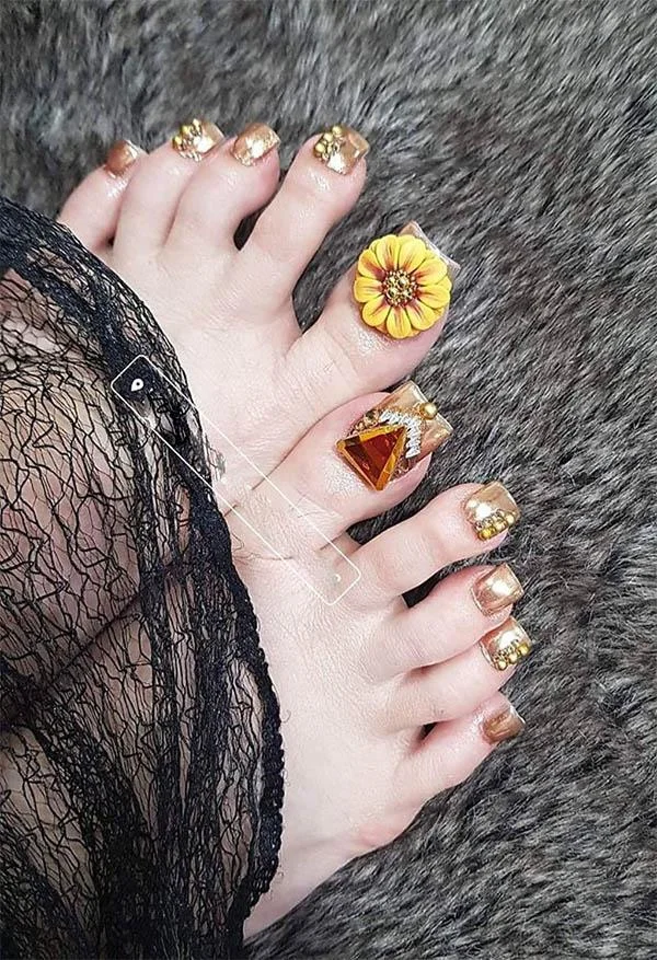 Mẫu nail chân đẹp đính đá vàng trên nền đen huyền bí
